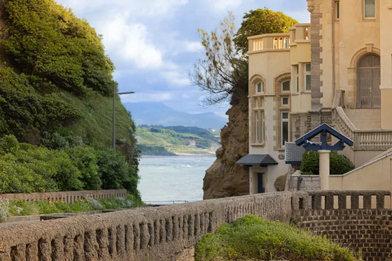 A villa above the coast road, the sea opening behind it