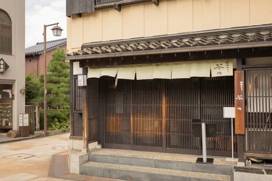 A shuttered machiya shopfront on an empty morning street