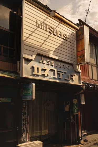 Weathered shop signage stacked above a dark storefront